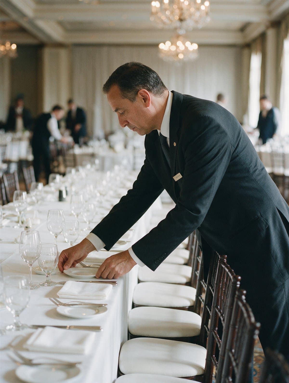 A banquet captain setting a ballroom table for an event