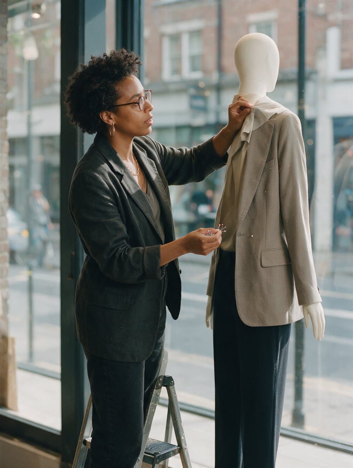 A visual merchandiser dressing a store window display